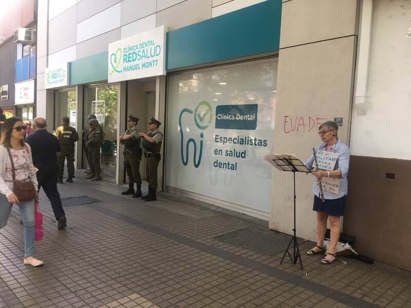 Mujer tocando flauta al lado de carabineros