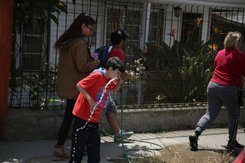 Niño tomando agua en manguera