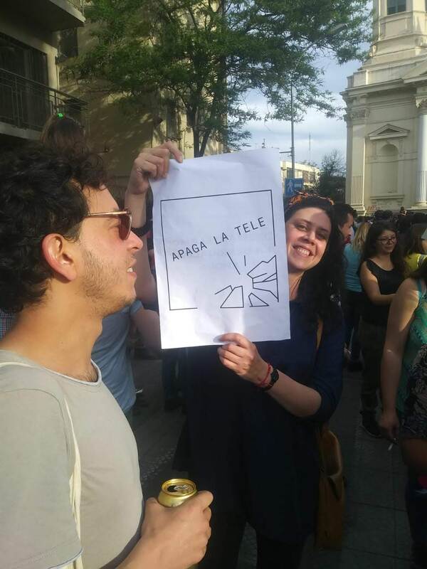Mujer con cartel "Apaga la tele"