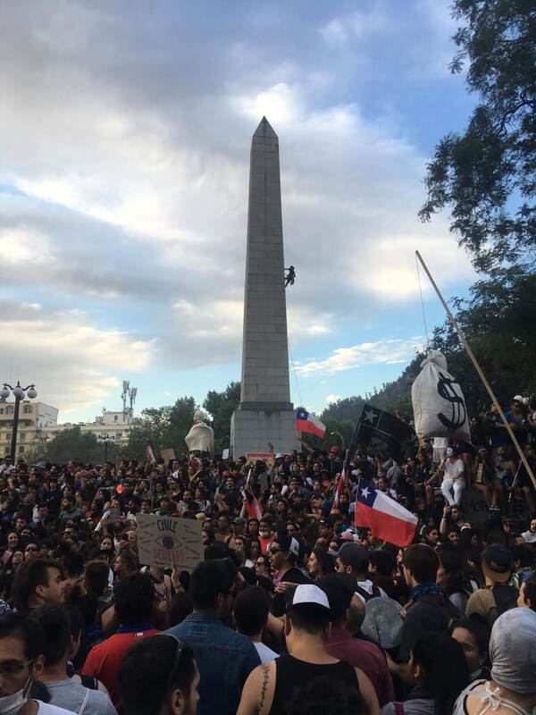 Persona escala el obelisco de Parque Balmaceda, Providencia