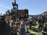 Personas reunidas en Plaza Dignidad y cartel "No más" 